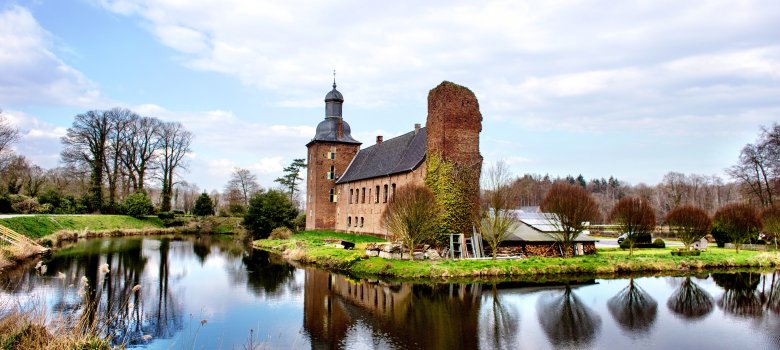 Entfernte Seitensicht auf die Mühle mit See im Vordergrund